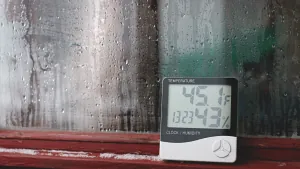 Condensation on a window beside a digital temperature and humidity meter