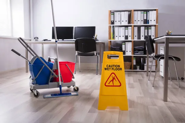 Mop bucket, trolley and caution wet floor sign in an office