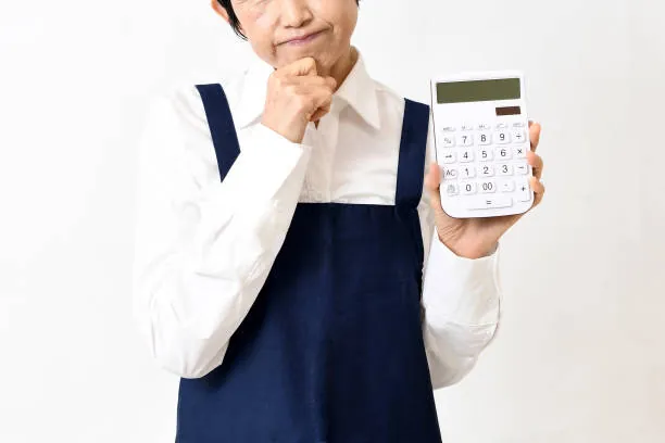 Cleaner holding a calculator while working out a cleaning quote