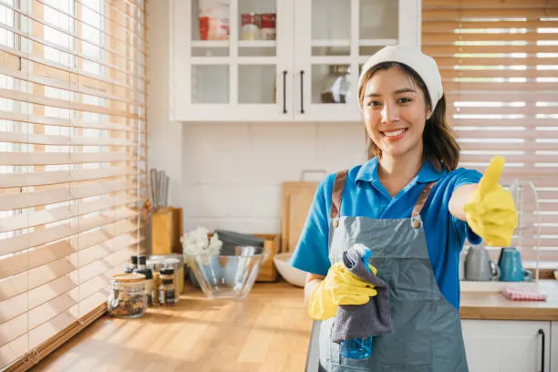 Cleaner giving a thumbs up in a tidy kitchen