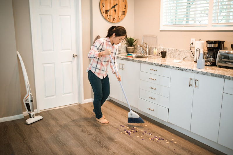 A part time cleaner sweeping floor.