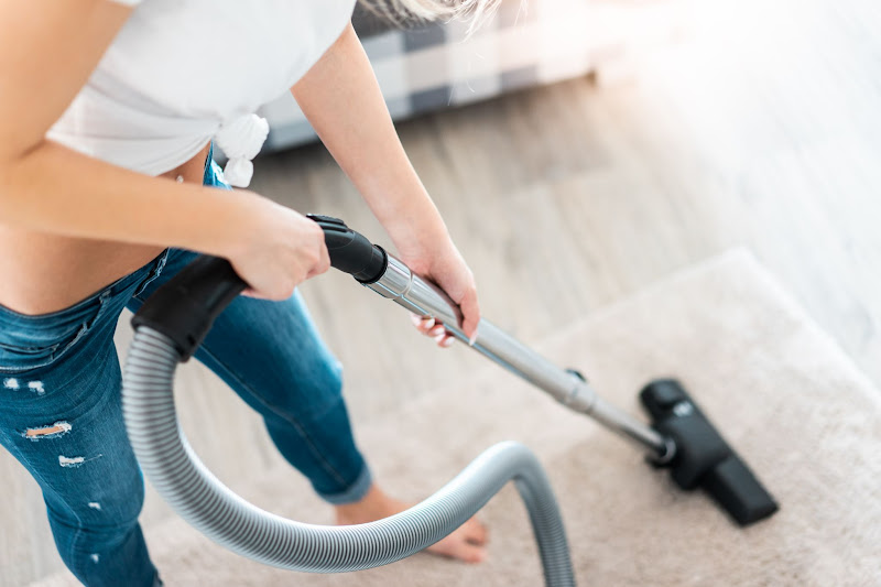 A woman vacuuming floor from a spring cleaning service company in Singapore.