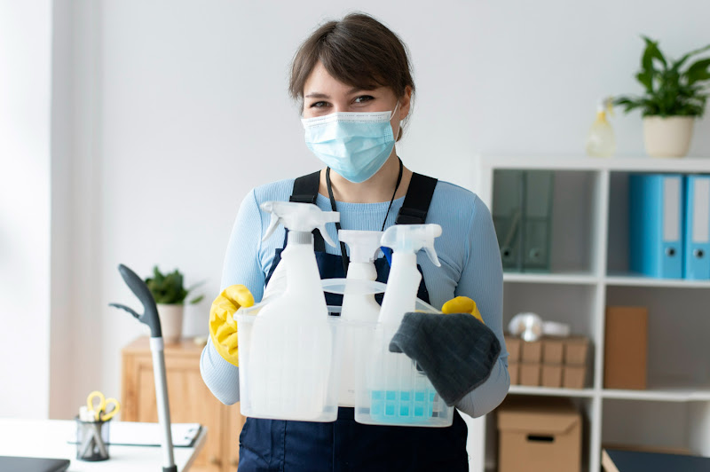 A woman holding a set of cleaning materials for hip cleaning service.