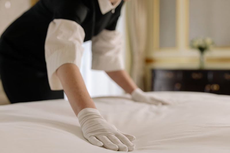 A woman fixing the bed after steam cleaning the mattress.