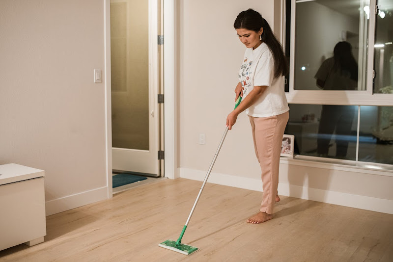 A woman mopping a varnished parquet floor.
